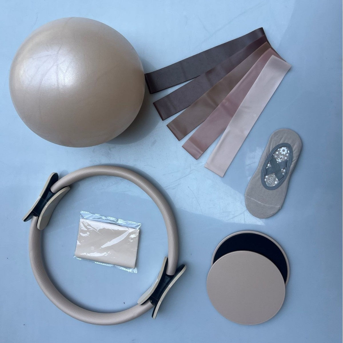 Sand Pilates mini ball, ring, fabric resistance bands, sliders and grip socks laid flat